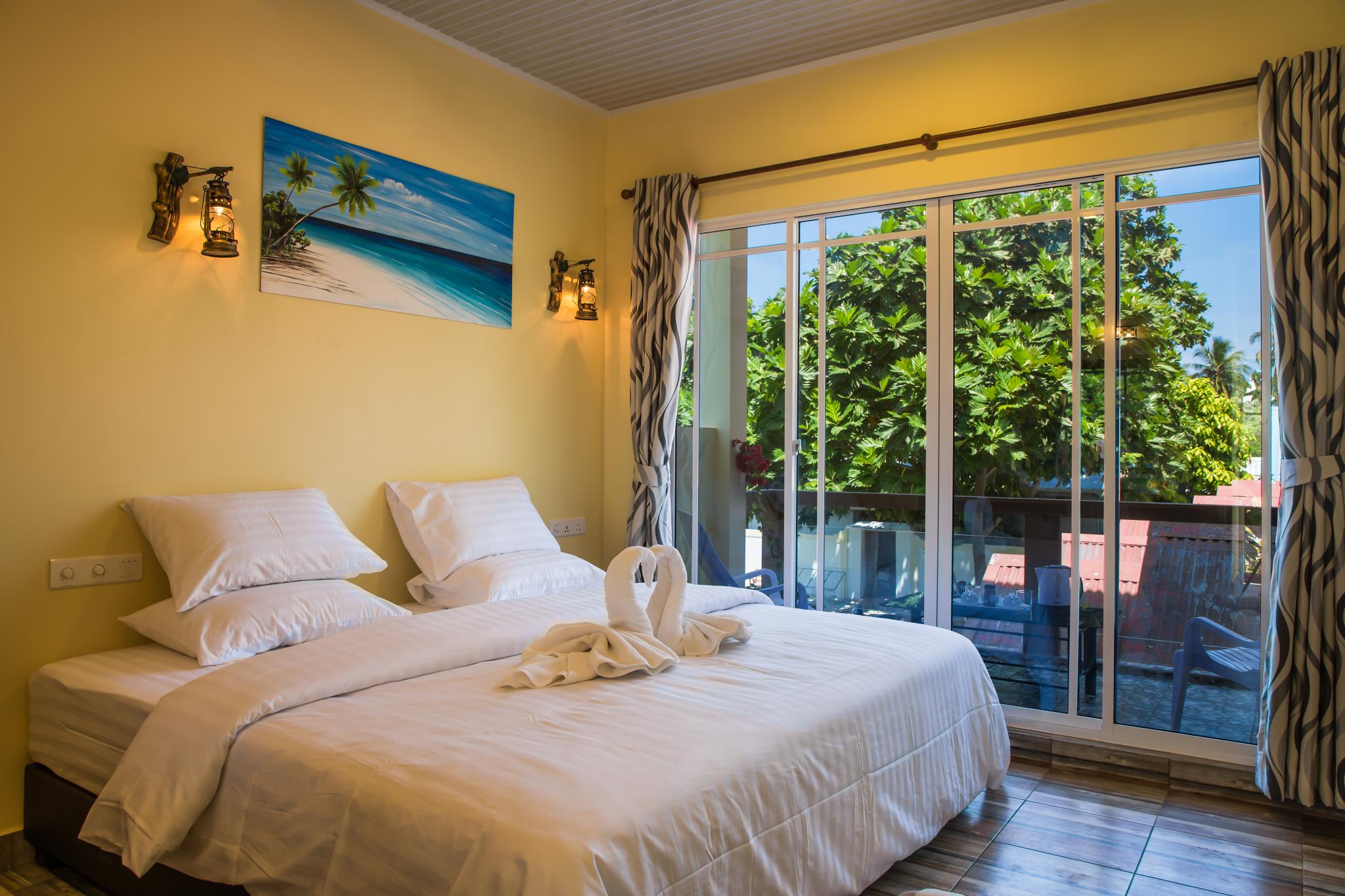 Cama doble junto a una puerta corredera de cristal que da al balcón