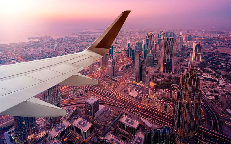 Vista desde la ventana de un avión de la resplandeciente ciudad de Dubái