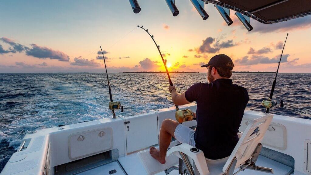 Angler fishing from a boat at sunset