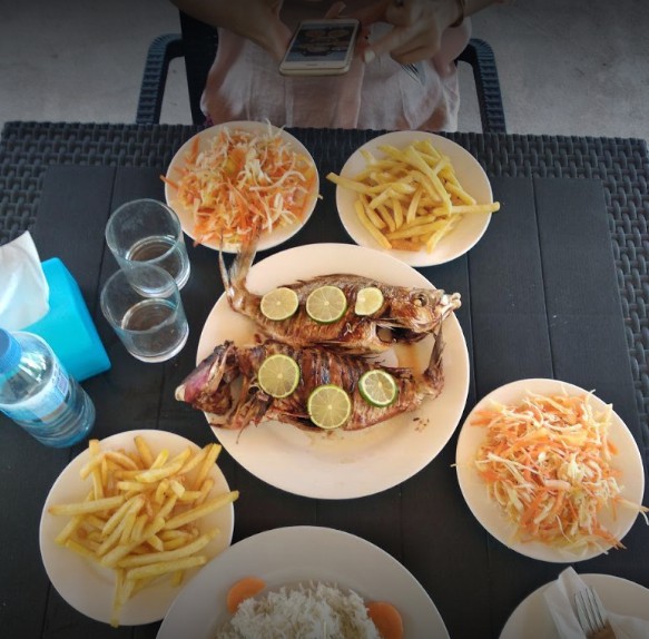 Grilled fish with fries and salad on a table