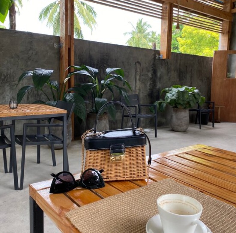 Outdoor table with coffee in a cafe garden on Thoddoo