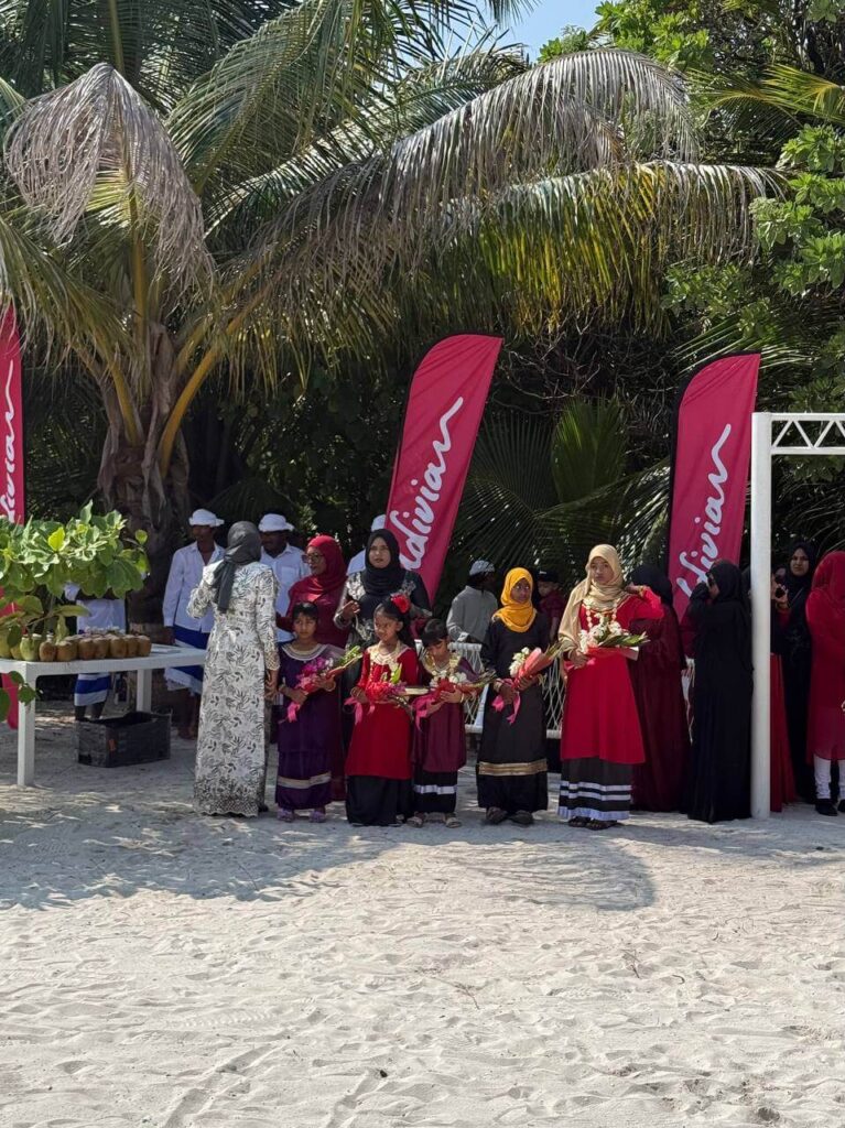 People gathered under red banners on the beach